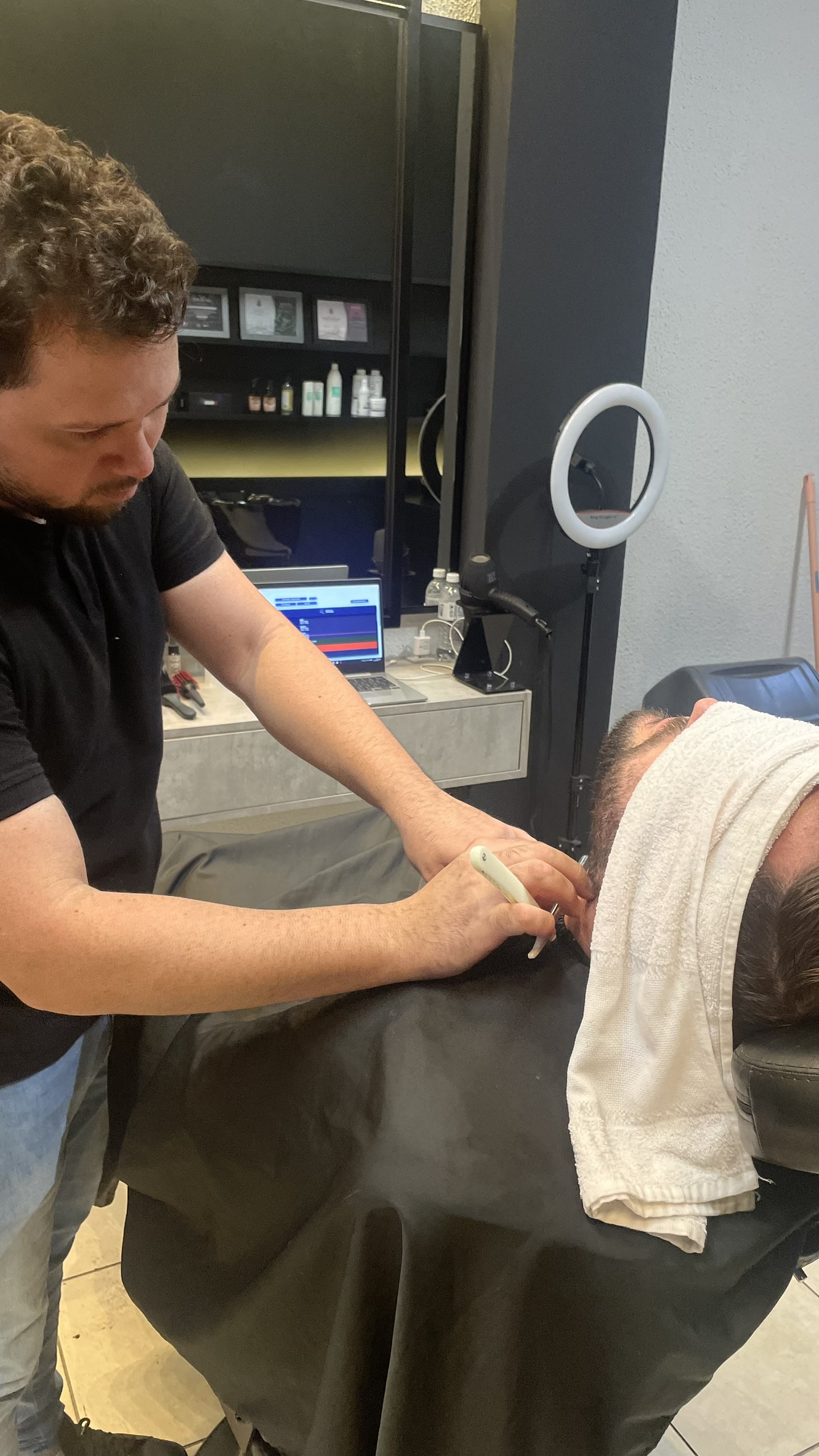 Barbeiro fazendo acabamento de barba